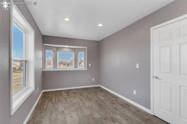 spare room with light wood finished floors, baseboards, and recessed lighting