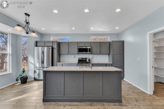 kitchen featuring gray cabinets, stainless steel appliances, and light countertops