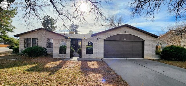 ranch-style home with a garage and a front lawn