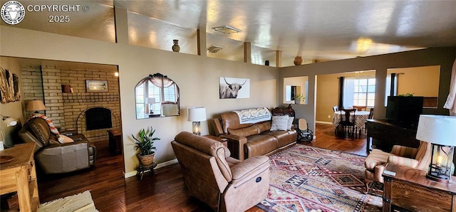 living room with lofted ceiling, dark hardwood / wood-style floors, and a brick fireplace