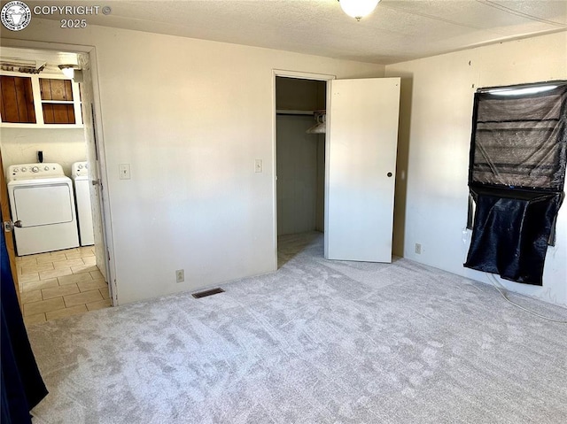 unfurnished bedroom with visible vents, carpet flooring, and washer and dryer