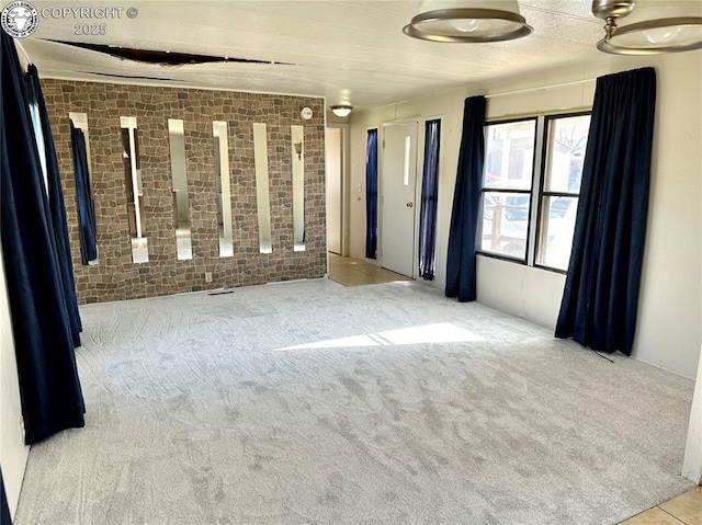 empty room featuring brick wall and carpet