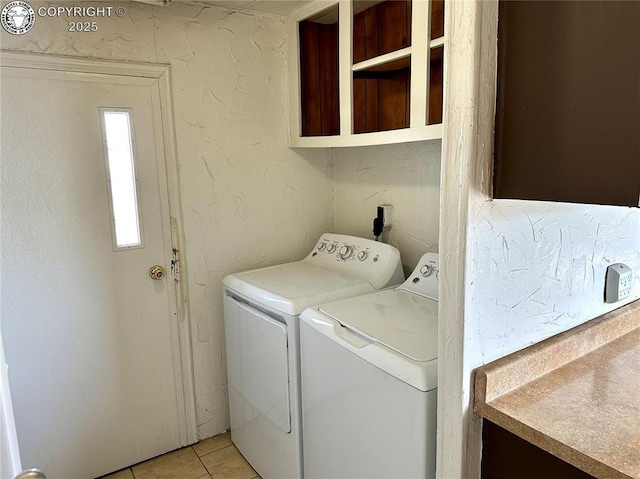 laundry room with washing machine and dryer, light tile patterned flooring, and laundry area