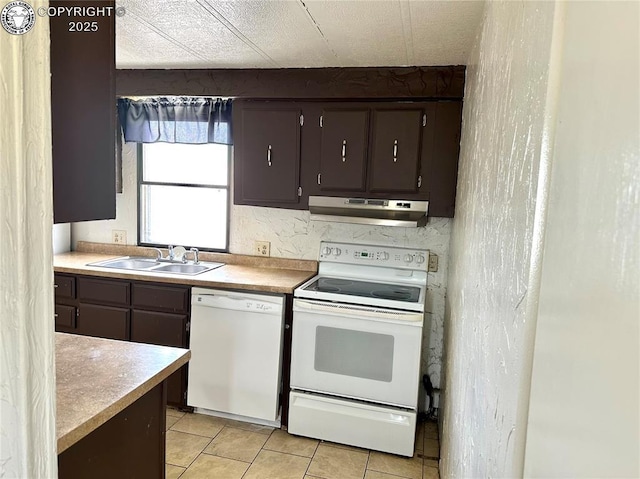 kitchen with a sink, light tile patterned flooring, white appliances, light countertops, and under cabinet range hood