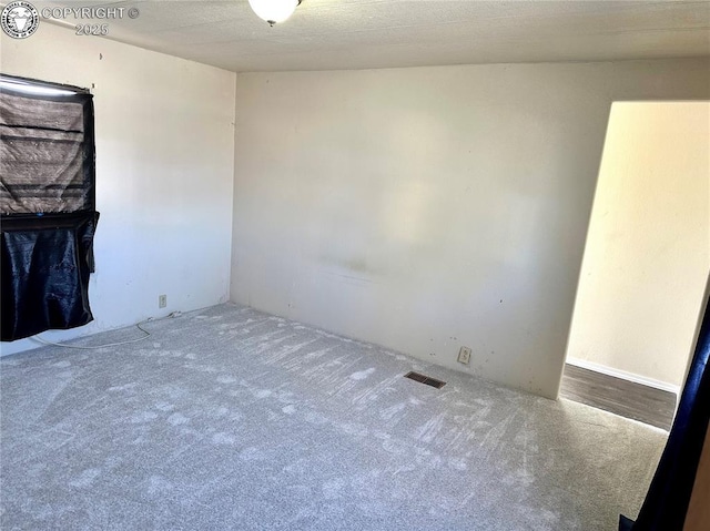 unfurnished room with visible vents and carpet floors