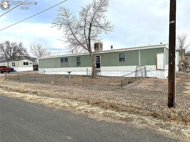 manufactured / mobile home featuring fence and central AC unit