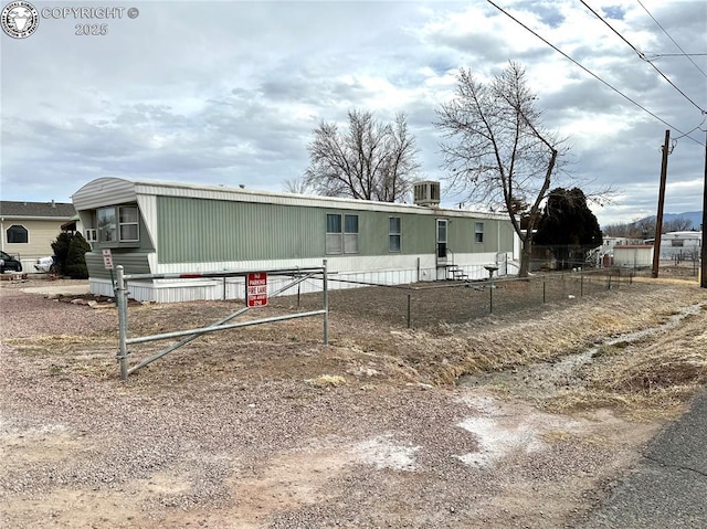 manufactured / mobile home with central AC unit and fence