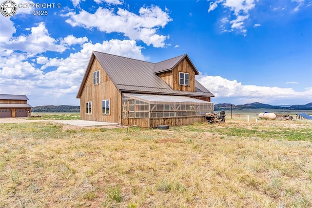 3491 County Road 215th Rd, Westcliffe, CO 81252 - view of property exterior with a metal roof, a mountain view, a patio, and a lawn