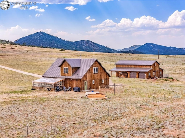 3491 County Road 215th Rd, Westcliffe, CO 81252 - back of property featuring a mountain view, a metal roof, an outbuilding, and a view of rural / pastoral area