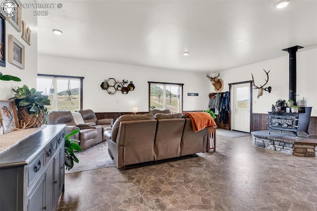 3491 County Road 215th Rd, Westcliffe, CO 81252 - living area featuring a wood stove, stone floors, a wainscoted wall, and recessed lighting