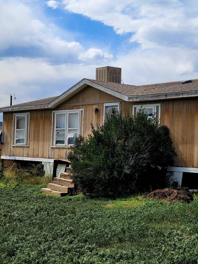 view of front of home featuring cooling unit and a front lawn