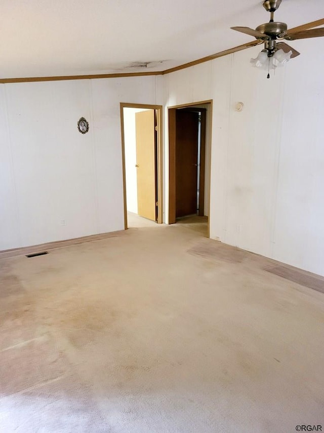 unfurnished room featuring crown molding, ceiling fan, and light carpet