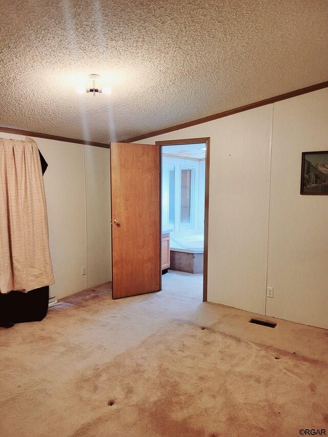 carpeted spare room with ornamental molding and a textured ceiling