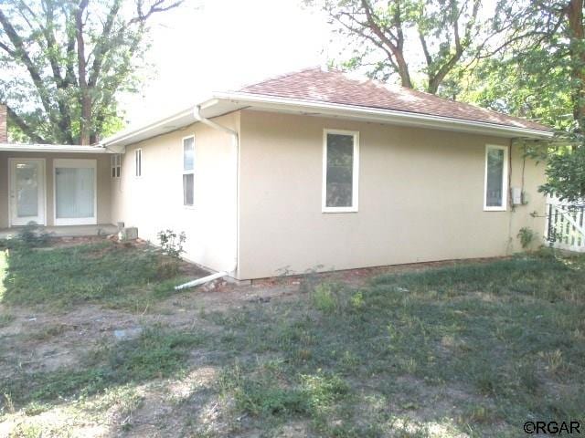 view of side of home with a yard