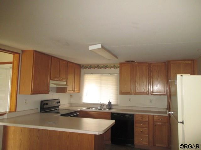 kitchen featuring sink, black dishwasher, kitchen peninsula, and electric stove