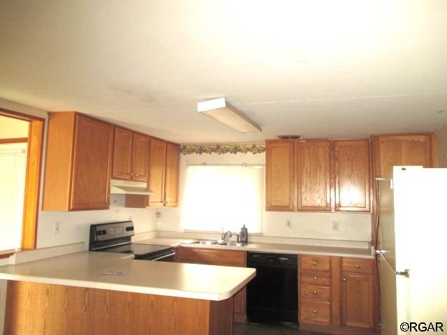 kitchen featuring dishwasher, sink, kitchen peninsula, and range with electric stovetop