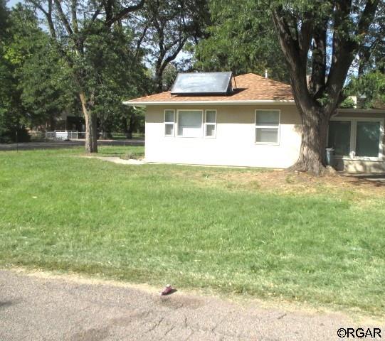 view of side of property featuring a lawn and solar panels