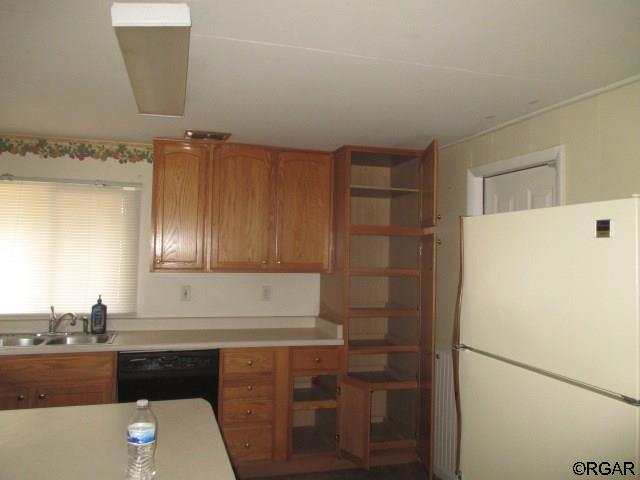 kitchen with white refrigerator, dishwasher, and sink