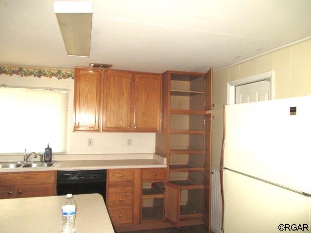 kitchen with white refrigerator, black dishwasher, and sink