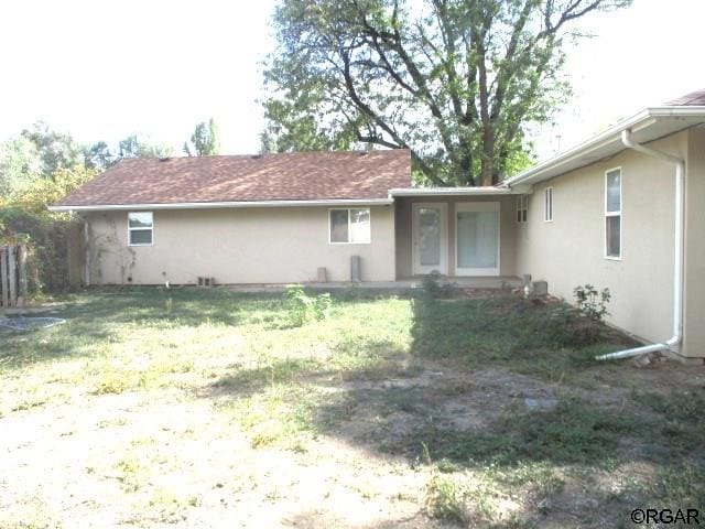 rear view of house featuring a lawn