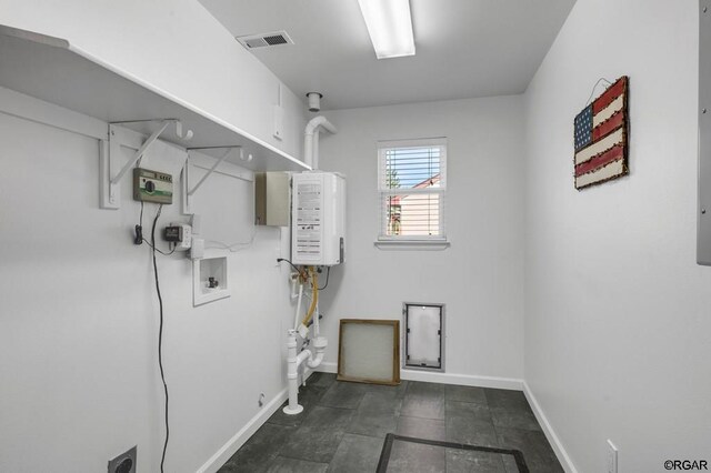 clothes washing area with washer hookup and tankless water heater