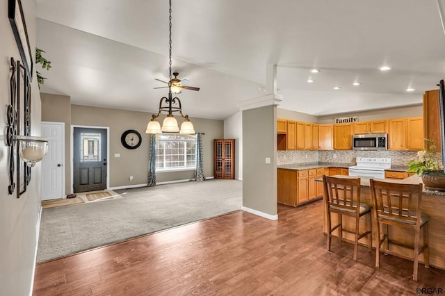 kitchen featuring carpet floors, white electric range, vaulted ceiling, and decorative backsplash