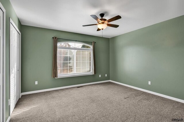 carpeted empty room featuring ceiling fan