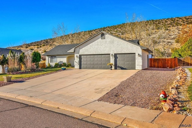 single story home with a garage and a mountain view