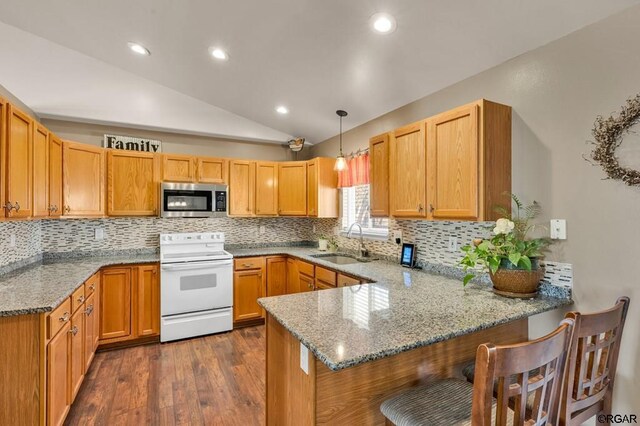 kitchen featuring white electric stove, hanging light fixtures, sink, and kitchen peninsula