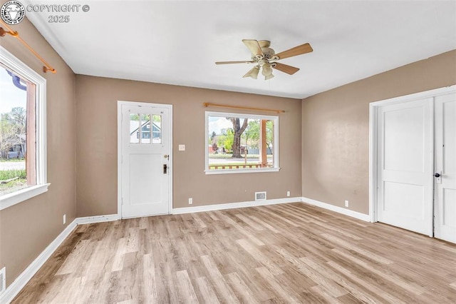 entrance foyer with light wood finished floors, a ceiling fan, and baseboards
