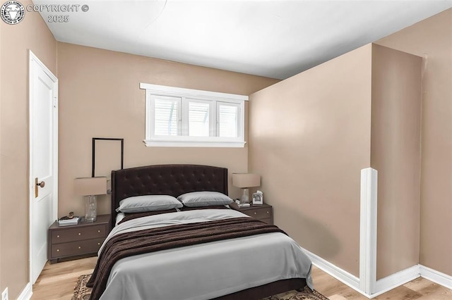 bedroom with light wood-style floors and baseboards