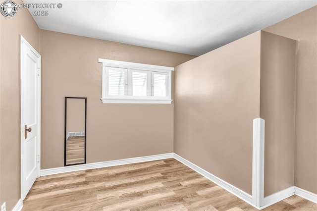 unfurnished room with wood finished floors and baseboards