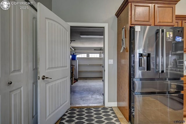 kitchen with brown cabinetry, tile patterned flooring, and stainless steel refrigerator with ice dispenser