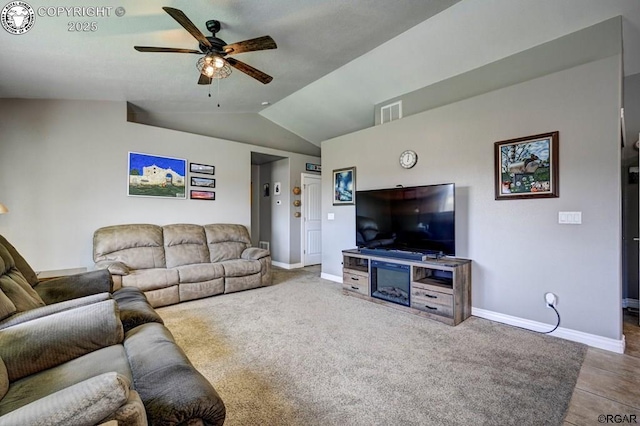 carpeted living area with visible vents, baseboards, ceiling fan, and vaulted ceiling