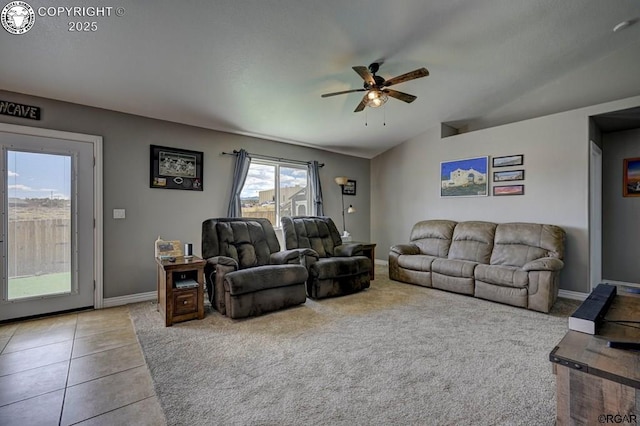 tiled living area featuring vaulted ceiling, a ceiling fan, and baseboards