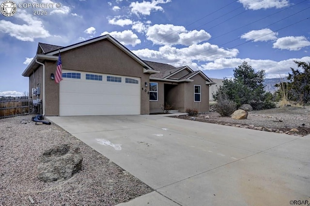 single story home featuring fence, a garage, driveway, and stucco siding