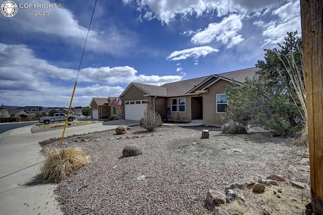 ranch-style home with stucco siding, an attached garage, and concrete driveway