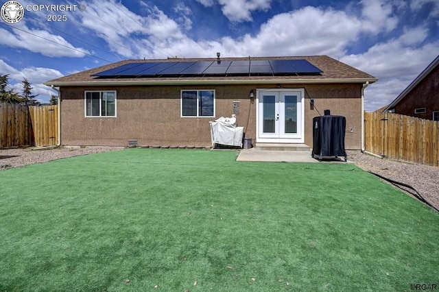 back of property with a yard, french doors, a fenced backyard, and stucco siding