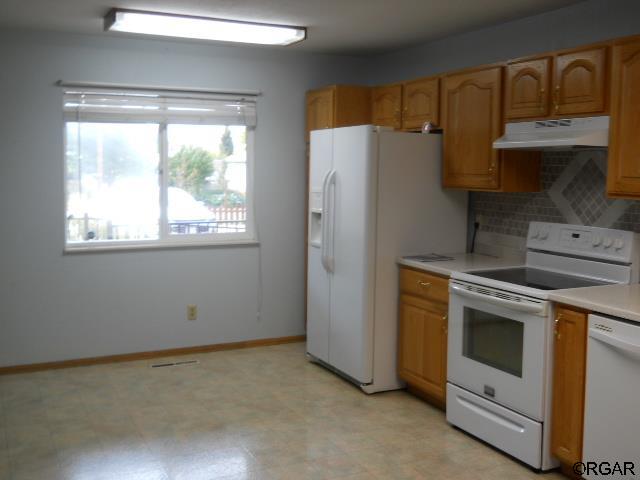 kitchen with tasteful backsplash and white appliances