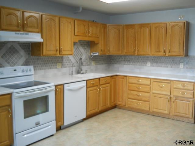 kitchen with sink, white appliances, and decorative backsplash