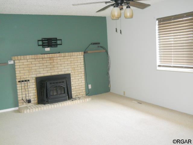 unfurnished living room featuring a textured ceiling and ceiling fan