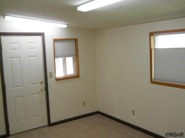 unfurnished room featuring light colored carpet