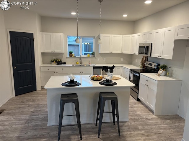 kitchen with stainless steel appliances, white cabinets, and a kitchen island