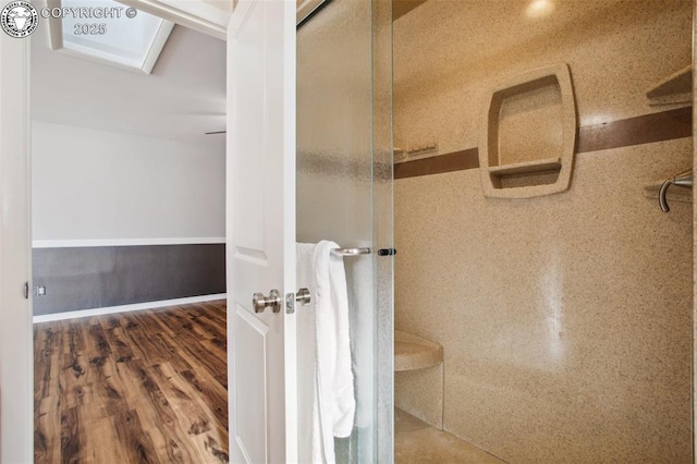 bathroom featuring wood-type flooring and a shower with shower door