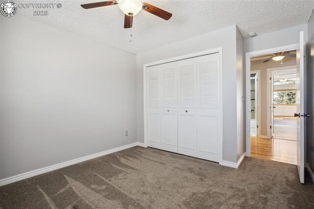 unfurnished bedroom with carpet floors, a textured ceiling, ceiling fan, and a closet