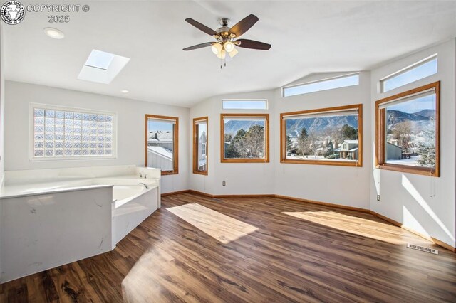 unfurnished bedroom featuring dark wood-type flooring, vaulted ceiling, and ceiling fan