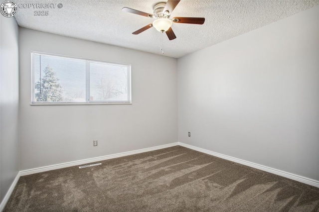 spare room with dark colored carpet, ceiling fan, and a textured ceiling