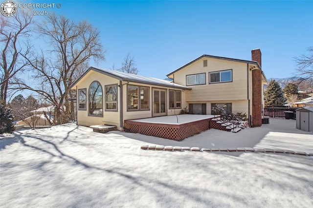 snow covered property featuring a sunroom