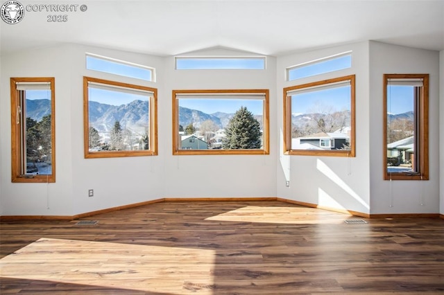 spare room featuring dark hardwood / wood-style flooring, a mountain view, and lofted ceiling