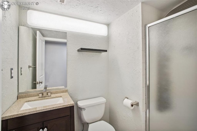 bathroom featuring vanity, a textured ceiling, toilet, and walk in shower